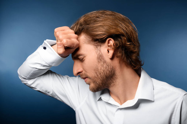 Young man suffering from headache on color background - Photo, Image
