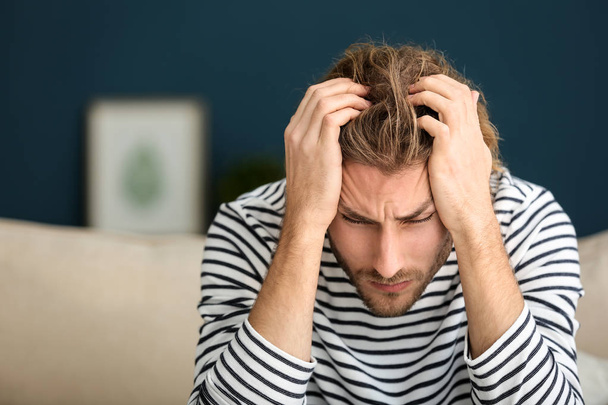 Young man suffering from headache at home - Φωτογραφία, εικόνα