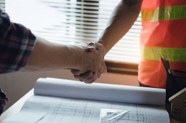 team of construction worker shaking hands with customer after finishing up business meeting to greeting start up project contract in office center at construction site, business and industry concept - Photo, Image