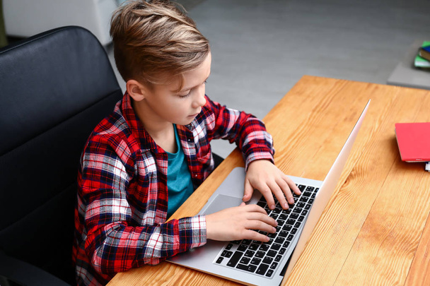 Lindo niño jugando videojuego en el ordenador portátil en casa
 - Foto, Imagen