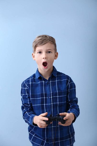 Емоційний хлопчик грає у відеоігри на кольоровому фоні
 - Фото, зображення