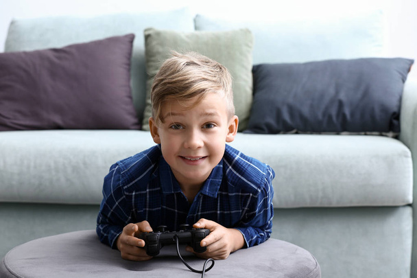 Cute boy playing video game at home - Foto, afbeelding
