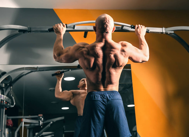 musculoso hombre entrenamiento en gimnasio - Foto, imagen