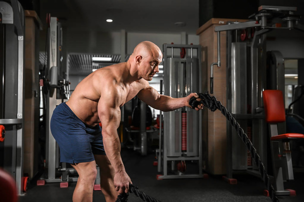 Muscular man training in gym - Photo, Image