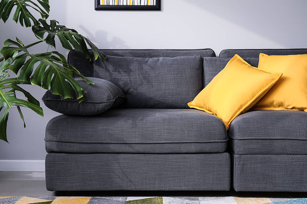 Cómodo sofá gris en el interior de la habitación
 - Foto, Imagen
