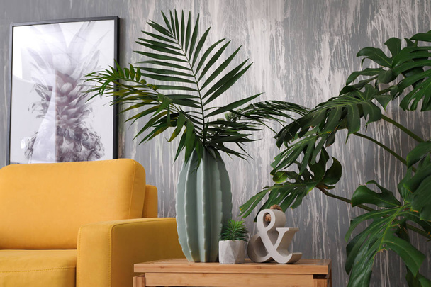 Green tropical leaves in interior of living room - Zdjęcie, obraz