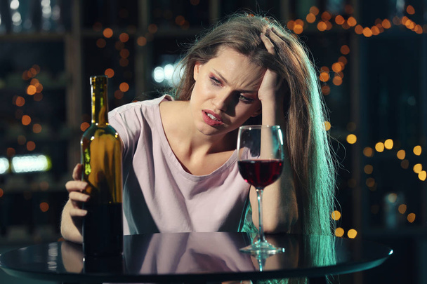 Jonge vrouw drinken van alcohol in staaf - Foto, afbeelding