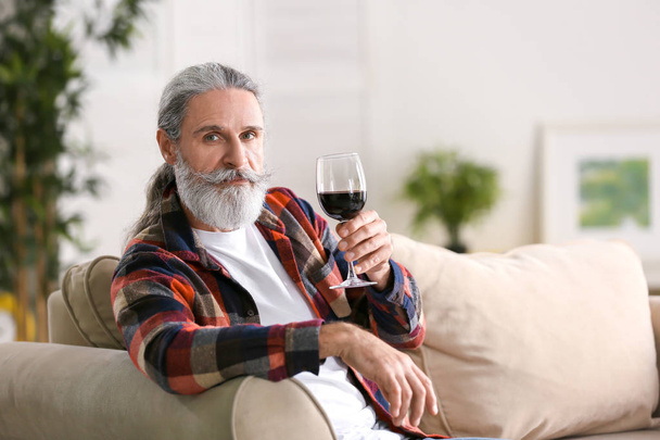 Senior man drinking wine at home - Foto, imagen