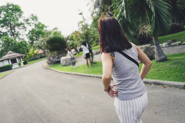 Parte trasera de la joven mujer caminando en el parque
 - Foto, imagen
