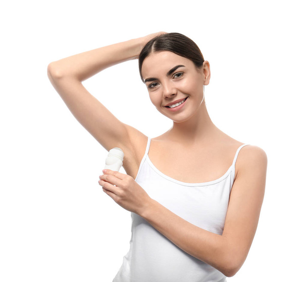Giovane donna utilizzando deodorante su sfondo bianco
 - Foto, immagini
