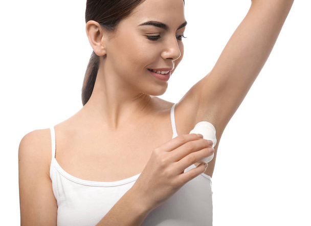 Młoda kobieta przy użyciu dezodorantu na białym tle - Zdjęcie, obraz