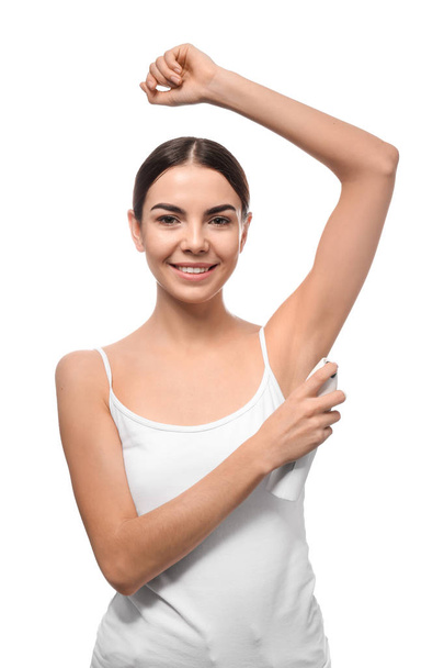 Young woman using deodorant on white background - Fotoğraf, Görsel