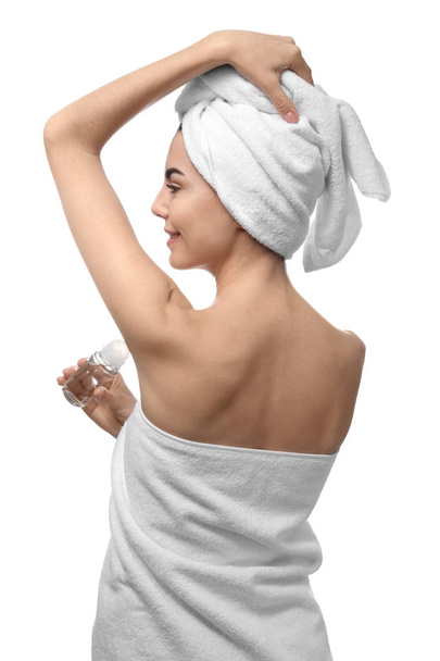 Mujer joven usando desodorante sobre fondo blanco
 - Foto, Imagen