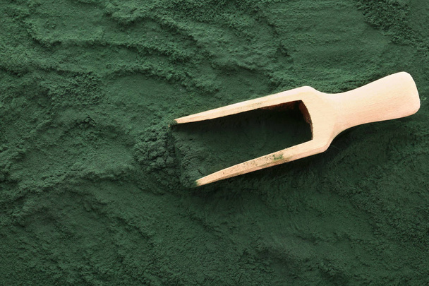 Cuillère en bois sur poudre de spiruline
 - Photo, image