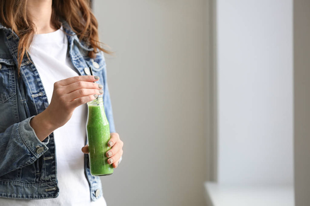 Woman with bottle of tasty smoothie indoors - Photo, Image