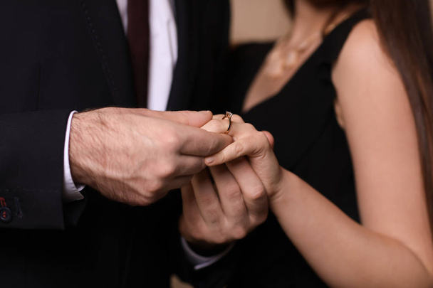 Jovem colocando anel no dedo de sua noiva após a proposta de casamento, close-up
 - Foto, Imagem