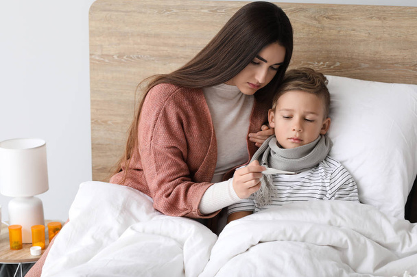 Az anya influenzás betegen gondozza a fiát otthon. - Fotó, kép