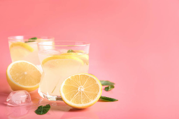 Glasses of tasty cold lemonade on color background - Фото, изображение
