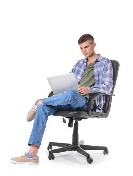Joven con portátil sentado en sillón sobre fondo blanco - Foto, Imagen
