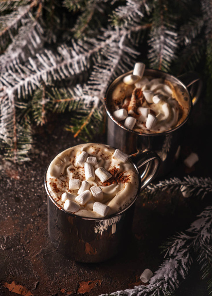 Hot drinks, chocolate with whipped cream and marshmallow in metal mugs, cozy christmas composition. - Photo, image