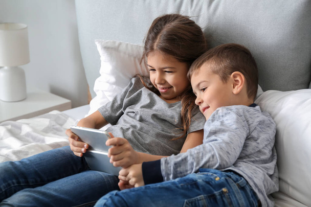Cute little children playing with smartphones at home - Foto, immagini