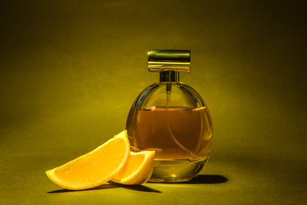 Bottle of perfume and lemon slices on color background - Photo, Image