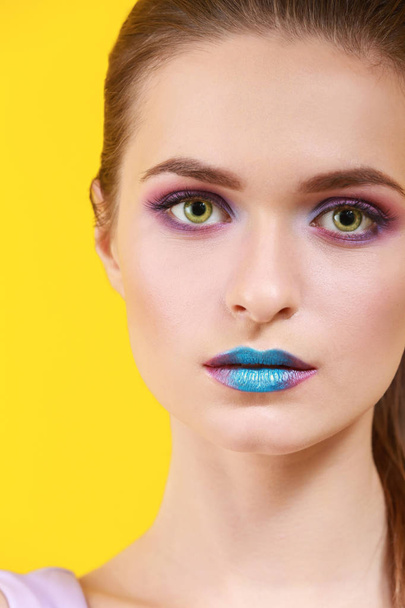 schöne junge Frau mit ungewöhnlichem Make-up auf farbigem Hintergrund - Foto, Bild