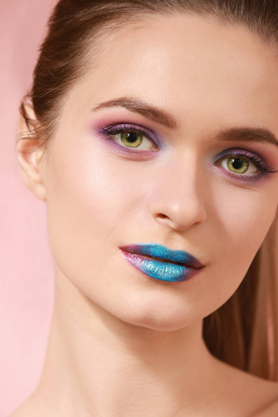 Schöne junge Frau mit ungewöhnlichem Make-up auf farbigem Hintergrund, Nahaufnahme - Foto, Bild
