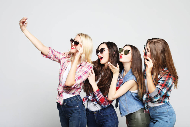  four happy teenage girls with smartphone taking selfie - Foto, afbeelding