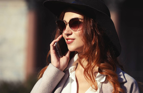 Lächelnde junge Frau telefoniert und spricht auf dem Smartphone - Foto, Bild