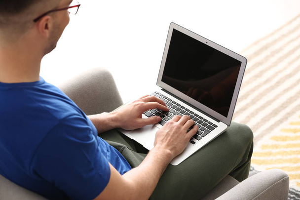 молодий чоловік працює з ноутбуком вдома
 - Фото, зображення