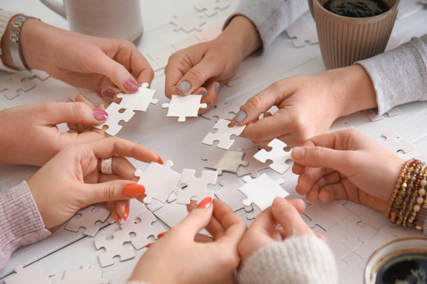 Lidé dělají puzzle u stolu - Fotografie, Obrázek