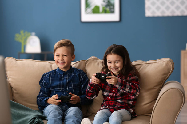 Χαριτωμένα παιδάκια παίζοντας παιχνίδι στον υπολογιστή στο σπίτι - Φωτογραφία, εικόνα