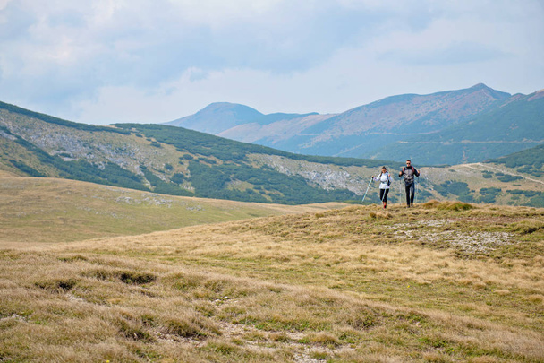 Sporty hikers on path with trekking poles - Fotó, kép