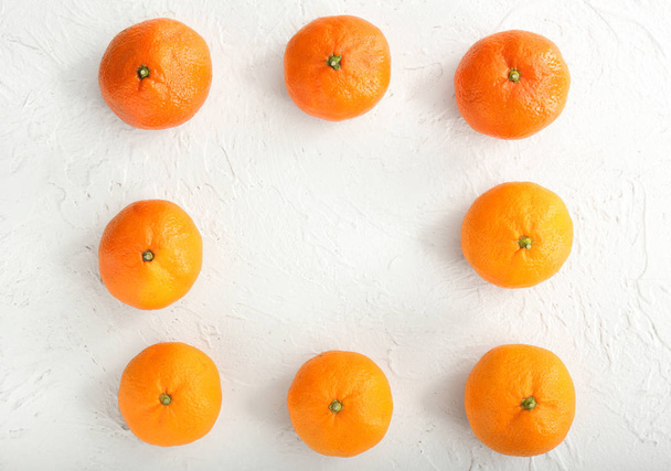 Frame made of tasty tangerines on white textured background - Photo, Image