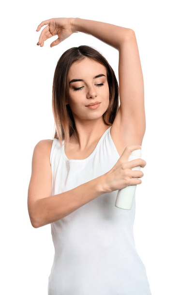 Beautiful young woman with deodorant on white background - Foto, Bild