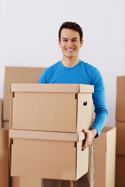 Happy young man holding a cardboard boxes - Фото, зображення