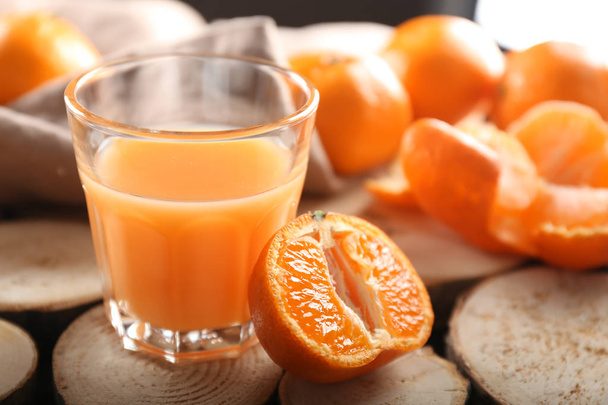 Glass of tasty tangerine juice on wooden table - Foto, Imagem
