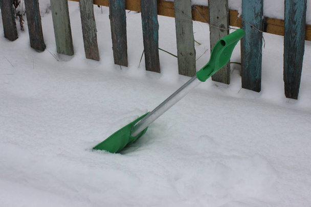 zöld lapát a hóeltakarítás, a ház udvarában. tiszta útját a bejáratnál, hogy a kapu a havas téli. - Fotó, kép