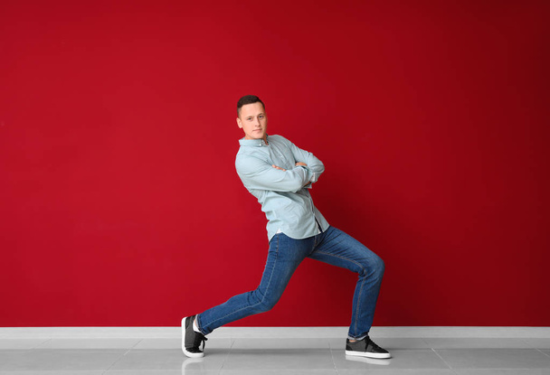Young man dancing near color wall - Photo, Image