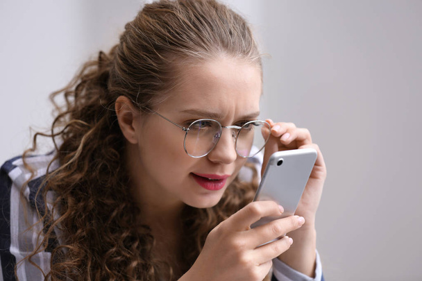 Mujer con mala vista tratando de leer el mensaje en la pantalla del teléfono móvil
 - Foto, Imagen