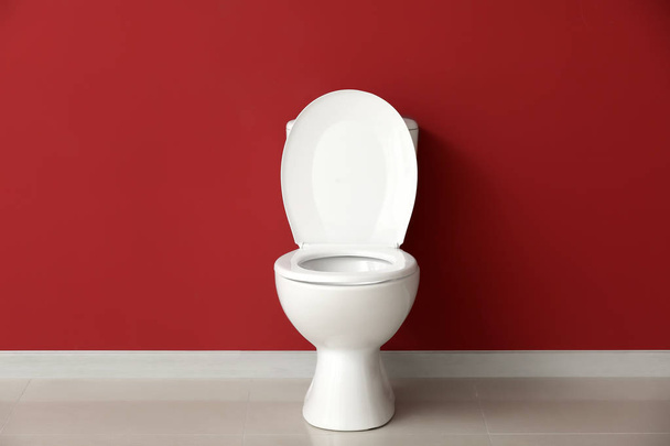 Modern ceramic toilet bowl near color wall in restroom - Fotoğraf, Görsel