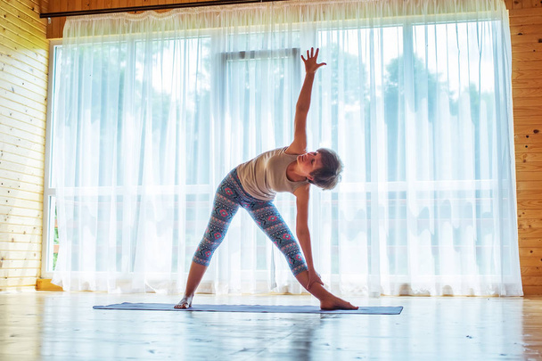 Caucasian woman is practicing yoga at studio - Φωτογραφία, εικόνα