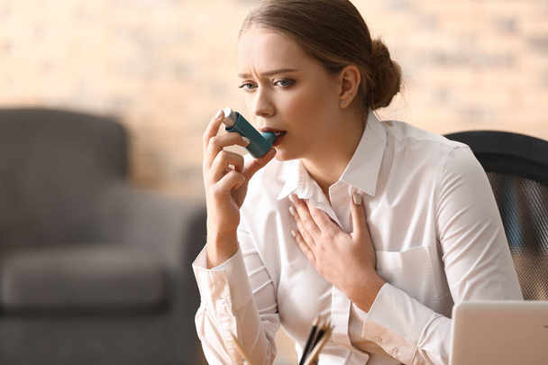 Młoda kobieta z inhalatora o astmy ataku w biurze - Zdjęcie, obraz