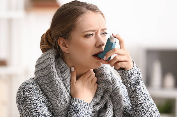 Jonge vrouw met inhalator heeft astma-aanval thuis - Foto, afbeelding