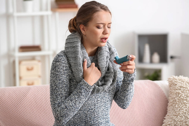 Mujer joven con inhalador que tiene un ataque de asma en casa - Foto, Imagen