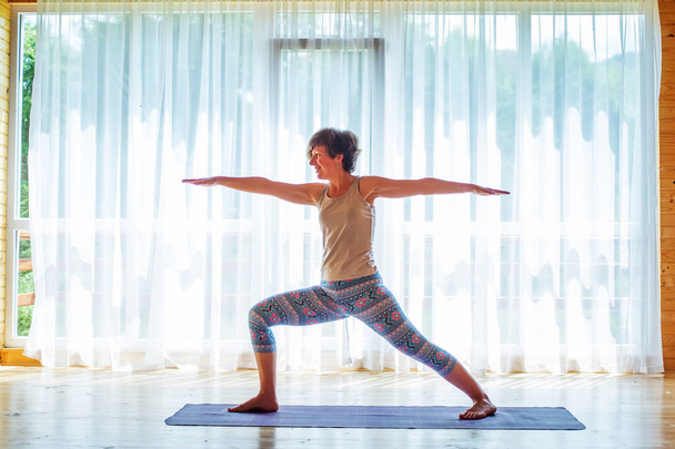 Caucasian woman is practicing yoga at studio - Fotoğraf, Görsel