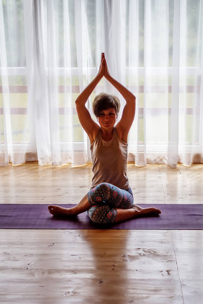 Donna caucasica sta praticando yoga in studio
 - Foto, immagini