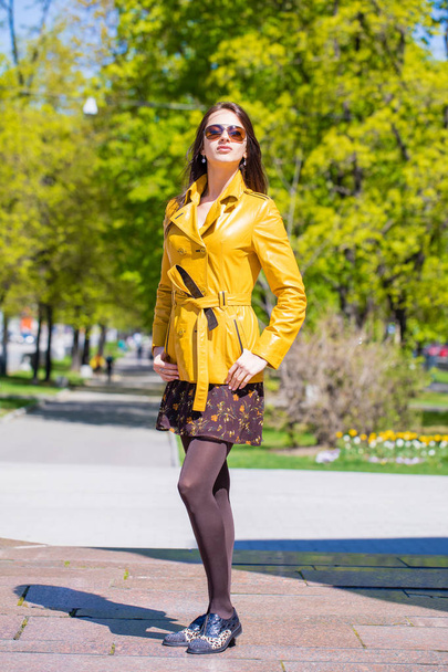 Young beautiful brunette woman in golden jacket in spring outdoors street - Φωτογραφία, εικόνα