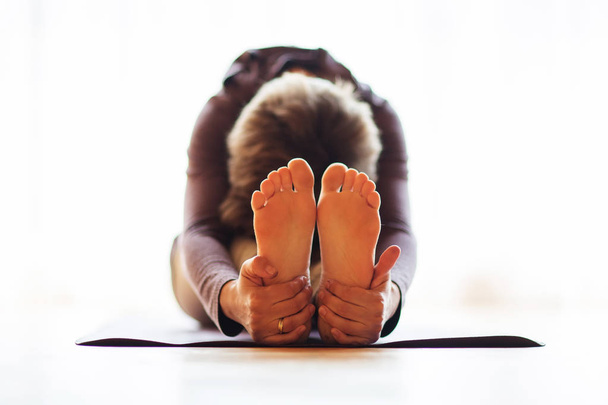 Caucasian woman is practicing yoga at studio - Foto, Imagem